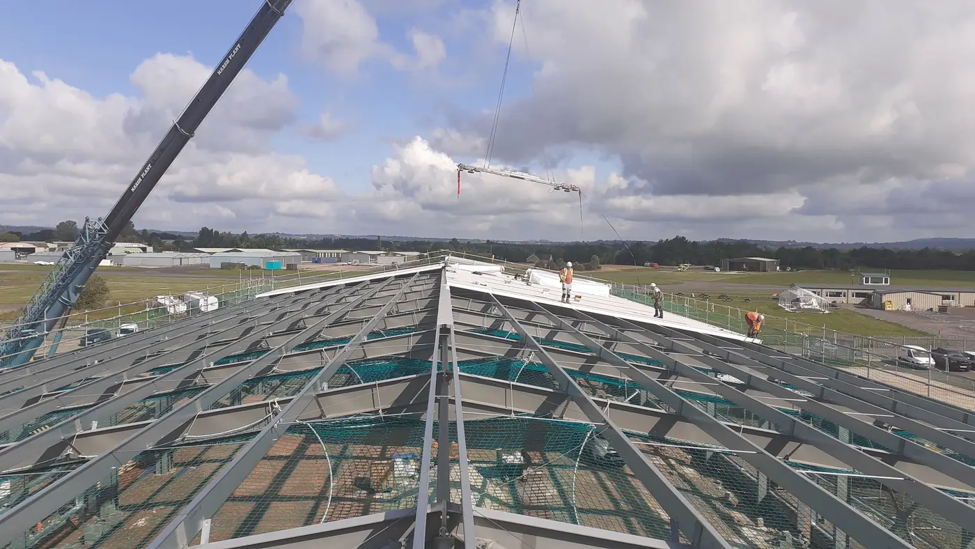 Composite roof panels being craned onto the steel frame