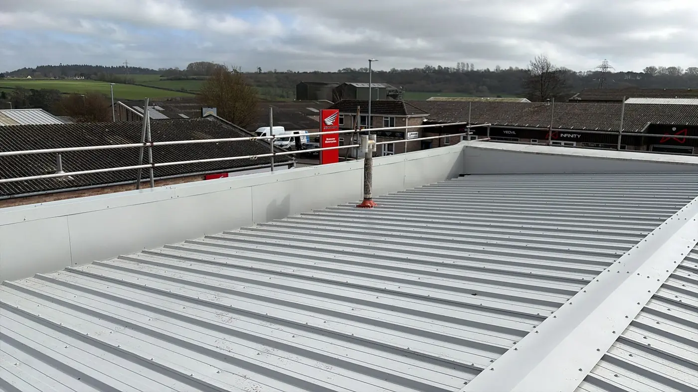 New roof panels meeting the parapet capping